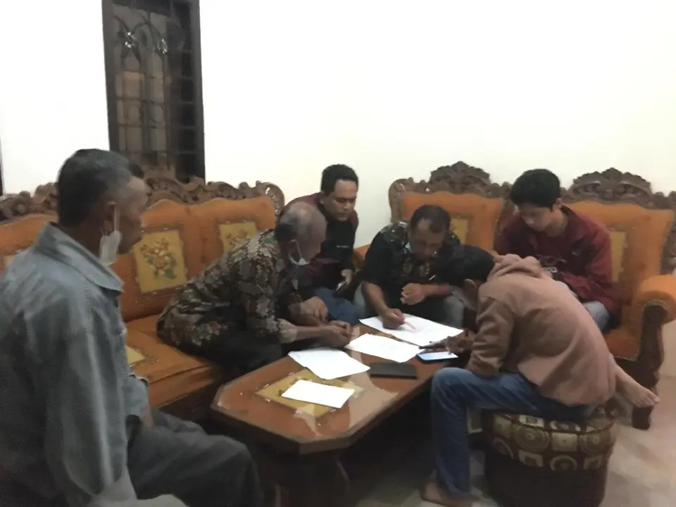Warga dan tim AWD membaca dokumen di meja